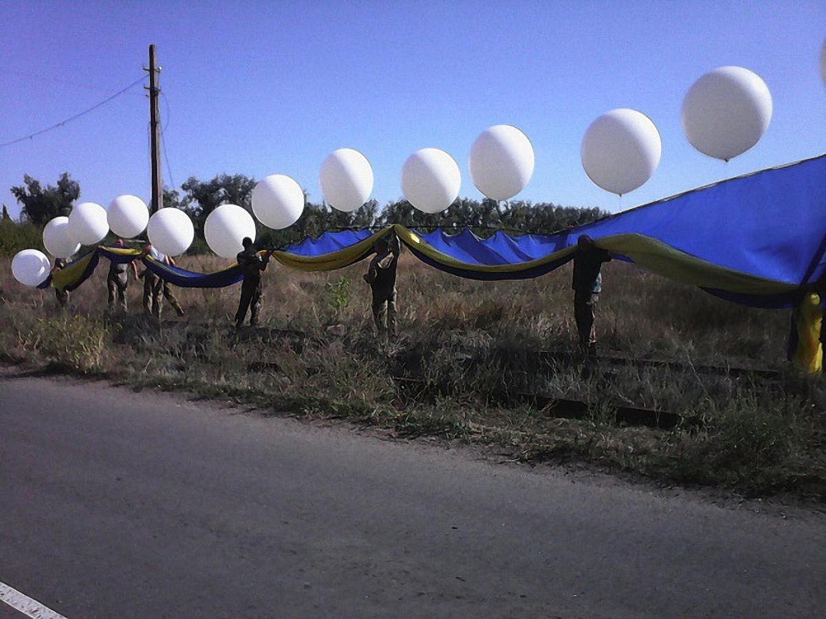 Бойцы подняли огромный флаг в небо на воздушных шарах - фото 1