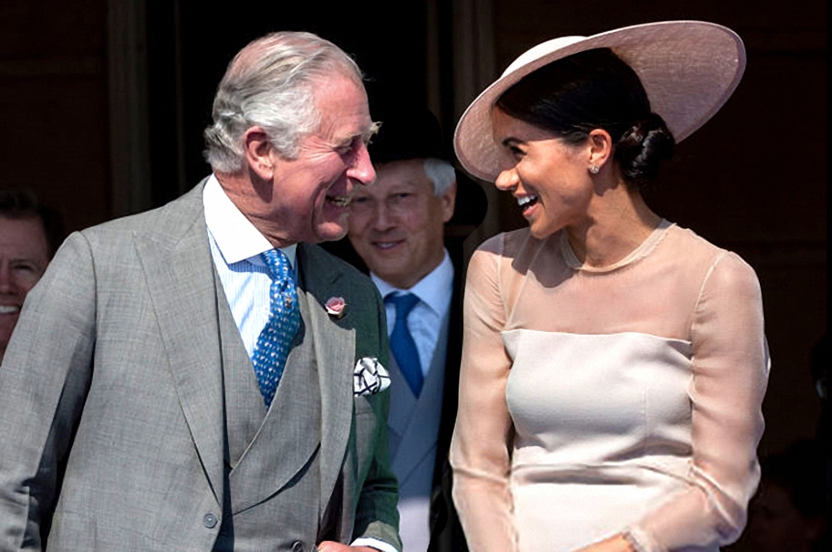 Принц Чарльз держит фото Меган Маркл в рамочке - фото 1